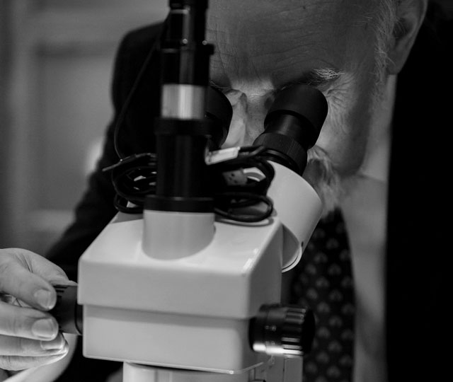 man looking into microscope.